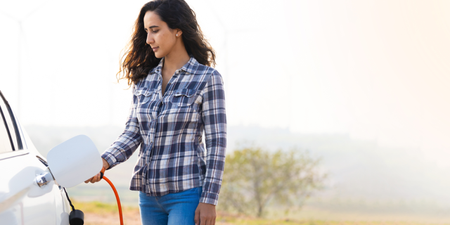 Mujer carga un vehículo eléctrico