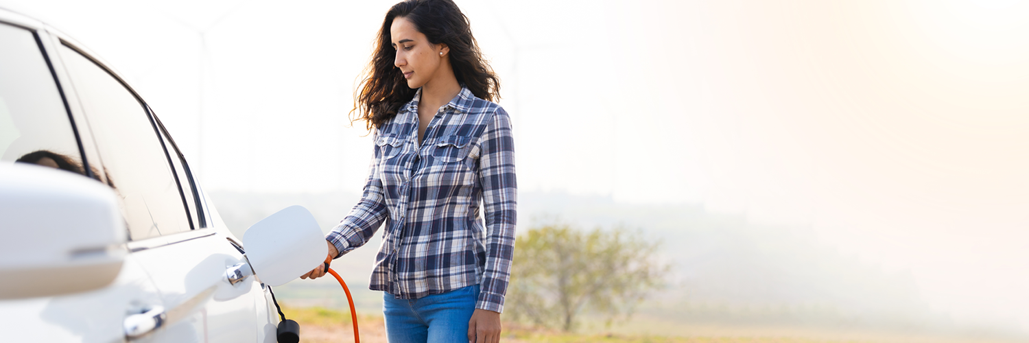 Mujer carga un vehículo eléctrico